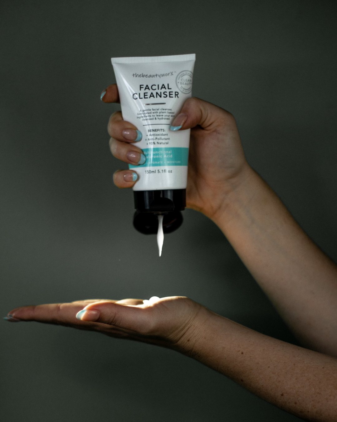 thebeautyworX facial cleanser squeezed into an open palm against a dark grey wall