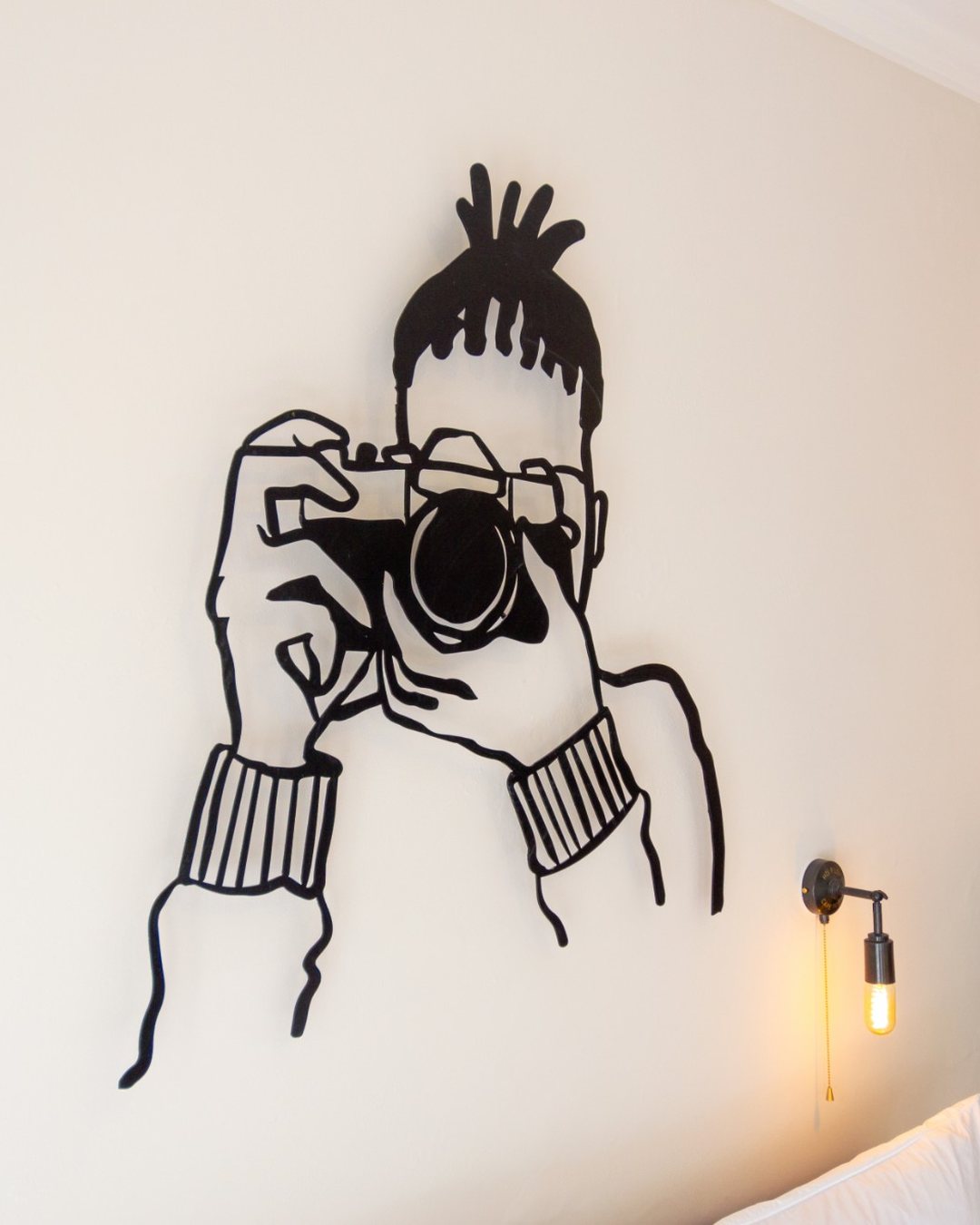 Hyatt House Johannesburg: steel line art of a photographer above the bed