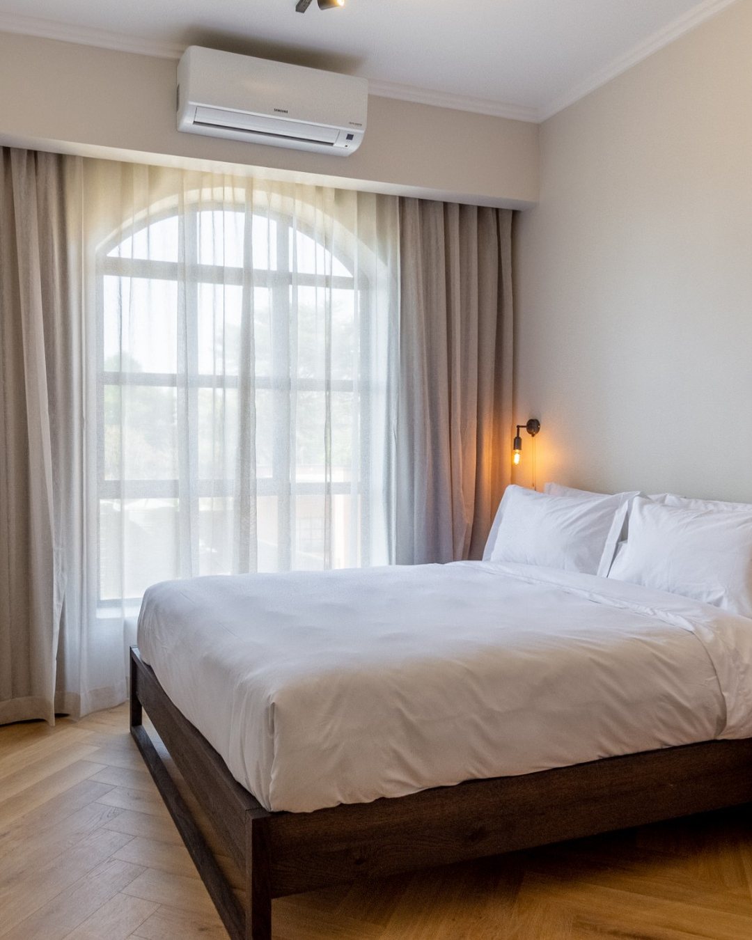 Hyatt House Johannesburg: a bedroom with an arched window and herringbone floor