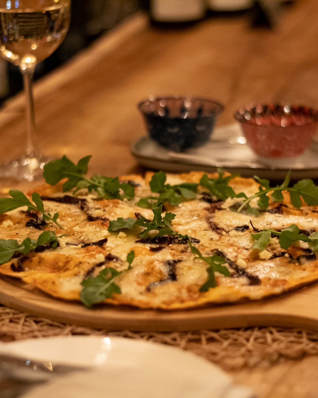 Val De Vine: a rocket-topped pizza on a wooden board at the bar
